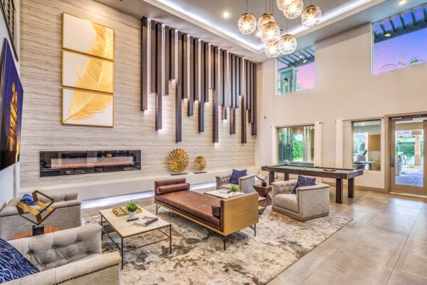 Clubhouse with pool table, plush seating, fireplace, and decorative art.