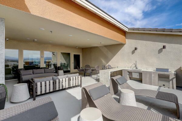 Aspire at Echelon apartments rooftop deck with lounge chairs, BBQ grill, and plush sectional.