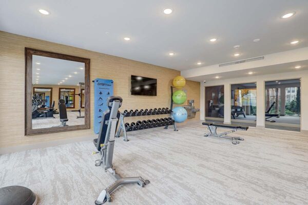 Aspire at Echelon apartments fitness center with weight benches and dumb bells.