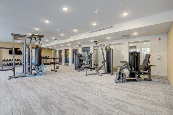 Aspire at Echelon apartments fitness center with weight machines and punching bag.