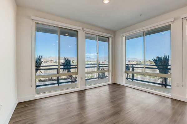 Aspire at Redwood apartment living room with wood style floor and large windows.