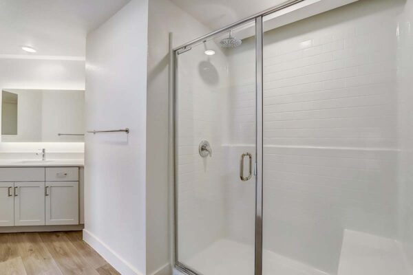 Aspire at Redwood apartment bathroom with large tiled glass wall shower.
