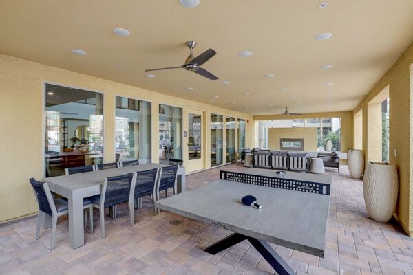 Aspire at Echelon apartments outdoor lounge with dining table, table tennis, and fireplace.