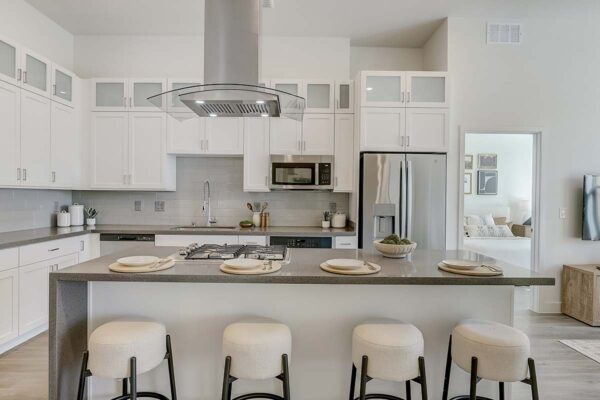 Aspire at Redwood apartment kitchen with white cabinets, gray counters, and stainless steel appliances.