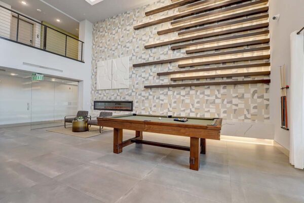 Aspire at Echelon apartments social club with pool table, lounge chairs, fireplace, and elegant decor.