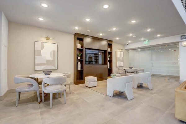 Aspire at Echelon apartments social club with plush seating, shelves with decor, and large TV.