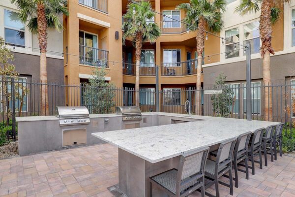 Aspire at Echelon apartments outdoor lounge with BBQ grills, bar area, and chairs.