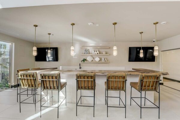 Aspire at Redwood apartments great room with community kitchen, bar stools, and TVs.