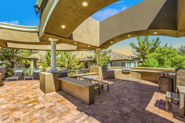 Outdoor grilling area with BBQ grills, dining tables, and lounge chairs.