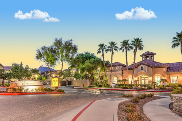Altessa apartments entry with lush landscaping and tall palm trees.