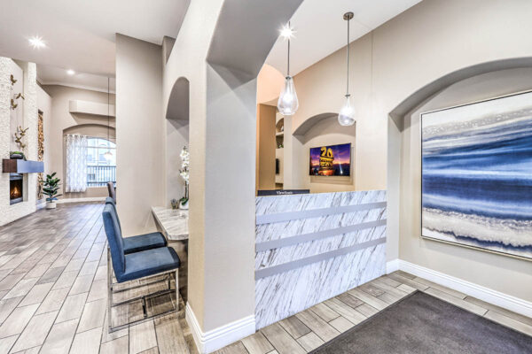 Leasing office with tile floor, stone desk, and large artwork.