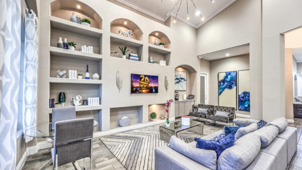 Lounge with plush seating, shelves with decor, TV, and large artwork.
