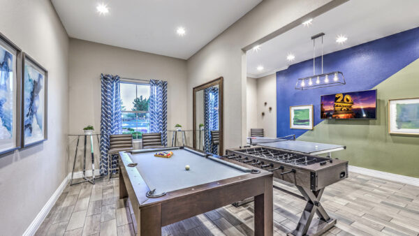 Game room with pool, foosball, and table tennis, TV, and framed artwork.