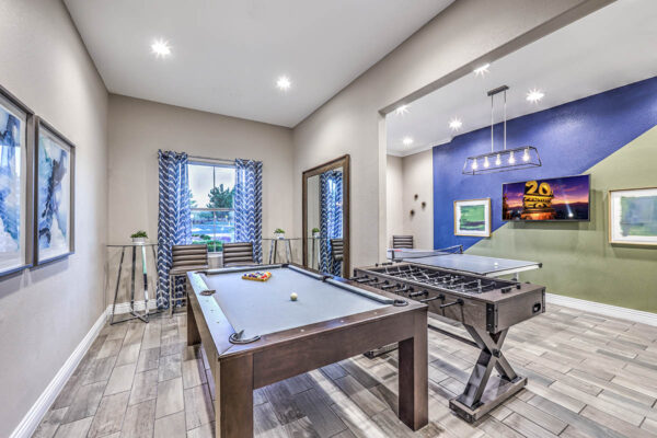 Game room with pool, foosball, and table tennis, TV, and framed artwork.
