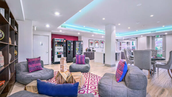 Lounge with vending machines, plush seating, poker table, and demo kitchen.