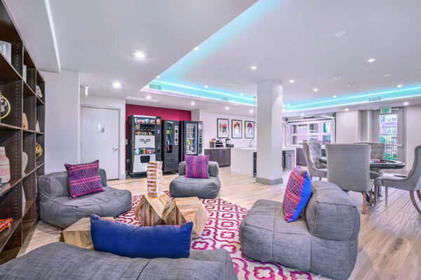 Lounge with vending machines, plush seating, poker table, and demo kitchen.
