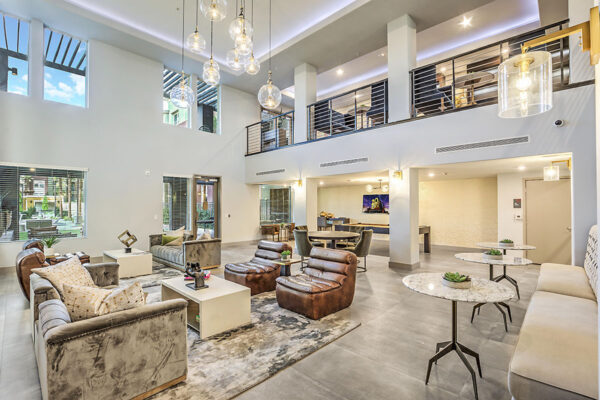 Clubroom with plush seating, tables with decor, glass light fixtures, and mezzanine floor.