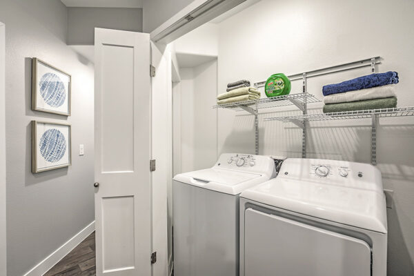 Laundry closet with washer, dryer and shelves with linens.