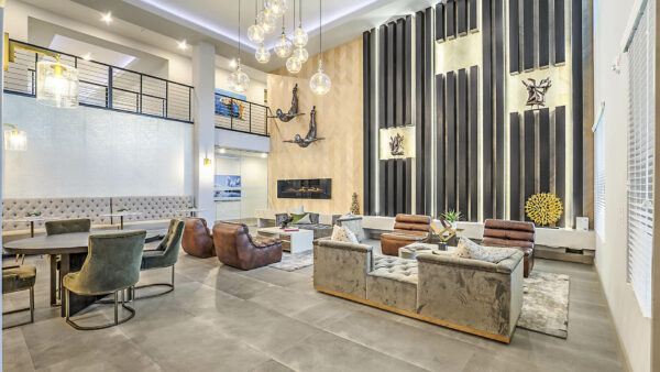 Clubroom with plush seating, dining table with chairs, glass light fixture, and mezzanine floor.