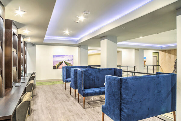 Mezzanine floor with plush seating and shelves with computers overlooking clubroom.