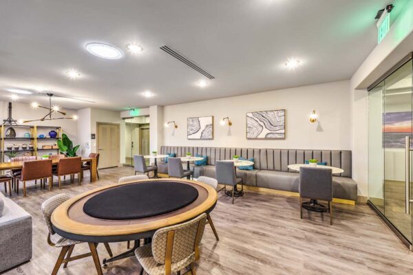 Lounge with games table, plush booths with tables, and framed artwork.