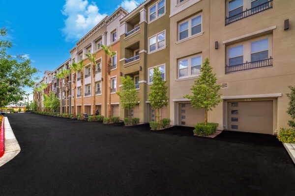 Aspire at Tesora apartments with lush landscaping, balconies, and garages.
