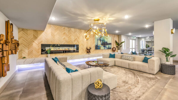 Lounge with plush seating, sculptural chandelier, and large fireplace.
