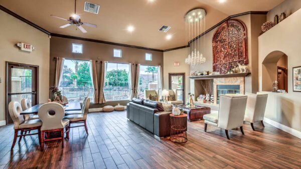 Clubhouse lounge with plush seating, elegant decor, dining table with chairs, and large windows.