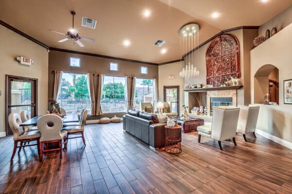 Clubhouse lounge with plush seating, elegant decor, dining table with chairs, and large windows.