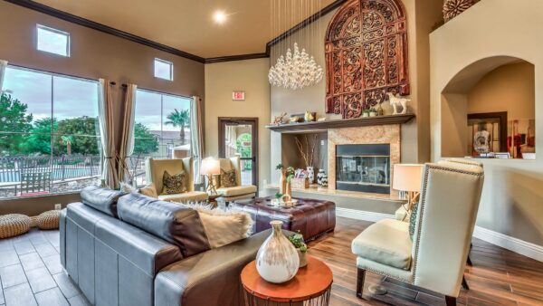 Clubhouse lounge with plush seating, elegant decor, fireplace, and large windows.