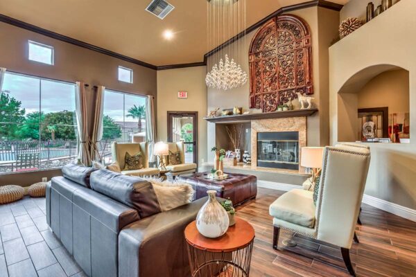 Clubhouse lounge with plush seating, elegant decor, fireplace, and large windows.