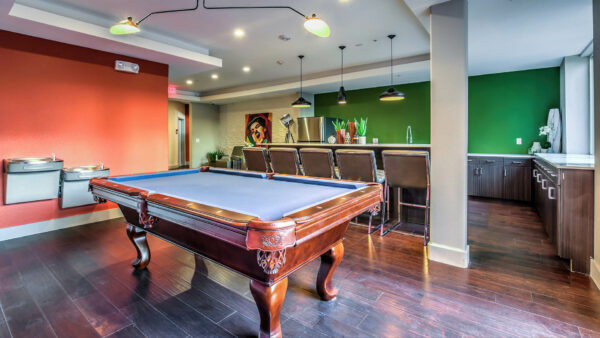 Demo kitchen with wood cabinets, tall counter, stainless steel appliances, and pool table.