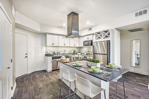 Northwest Las Vegas apartment kitchen with wood floor, white cabinets, grey counters, and stainless steel appliances.