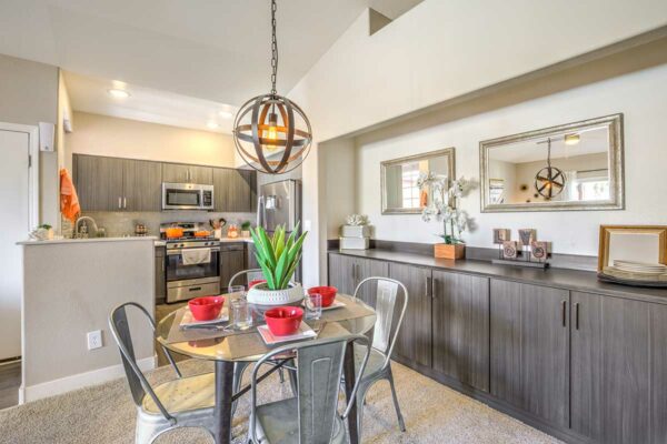 Kitchen area with modern kitchen, cabinets with decor, and dining table with metal chairs.