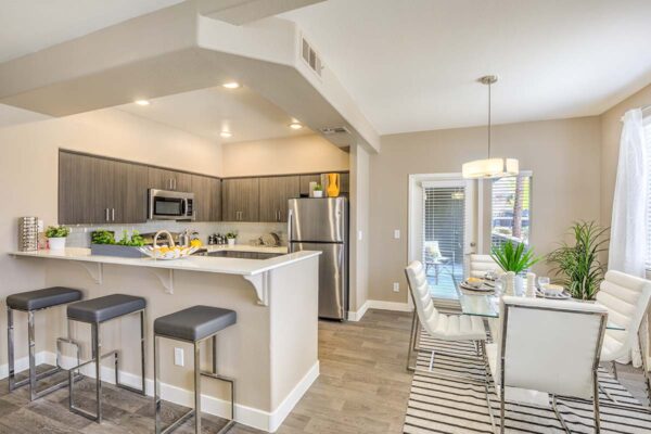 Kitchen with wood cabinets, light counters, stainless steel appliances, and comfortable dining area.