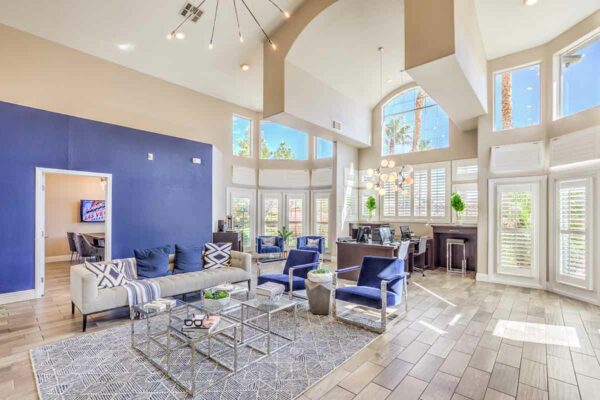 Lounge with plush seating, computer desks with chairs, blue accent wall, and large windows.