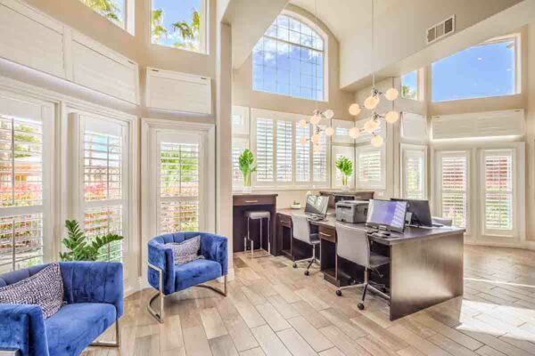 Business center with computer desks, comfortable chairs, and large windows.