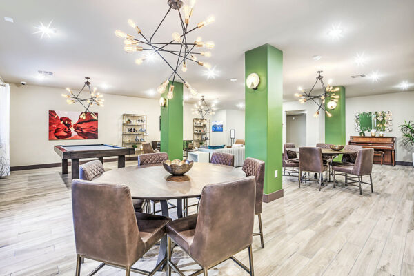 Clubhouse with pool table, metal light fixtures, and shelves with eclectic decor.