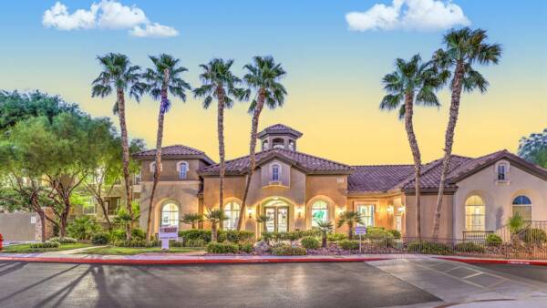 Altessa apartments entry with lush landscaping and tall palm trees.