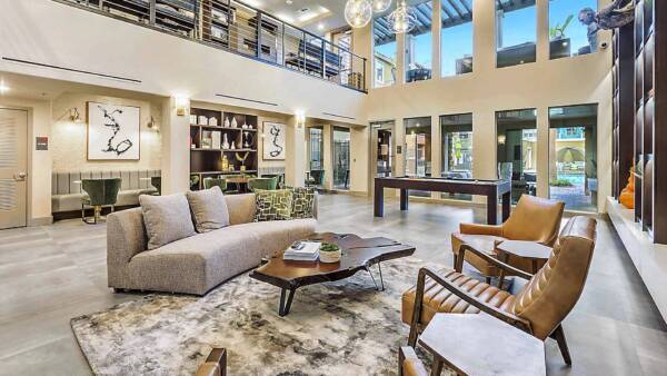 Radiance at Grand Canyon clubhouse with plush chairs, pool table, shelves with decor, and large windows.