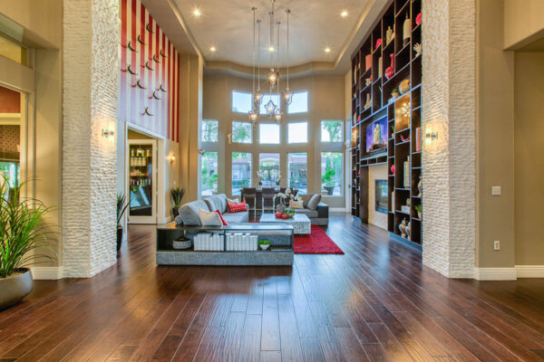 Clubhouse with vaulted ceilings, plush seating, fireplace, and shelves with decor.