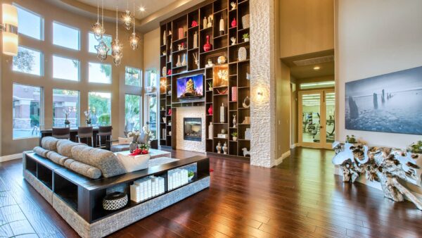 Clubhouse with vaulted ceilings, plush seating, fireplace, and shelves with decor.