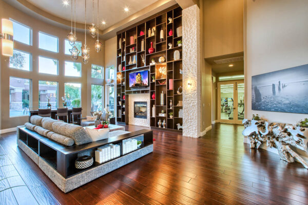 Clubhouse with vaulted ceilings, plush seating, fireplace, and shelves with decor.