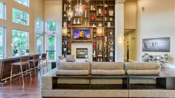 Clubhouse with vaulted ceilings, plush seating, fireplace, and shelves with decor.