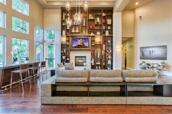 Clubhouse with vaulted ceilings, plush seating, fireplace, and shelves with decor.