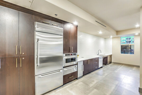Demo kitchen with tile floor, wood cabinets, stone counter, and stainless steel appliances.