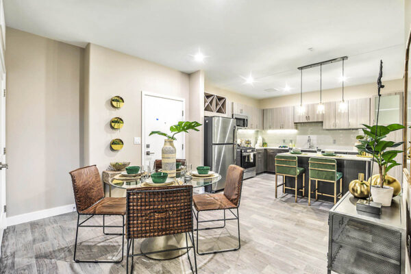 Apartment living area with comfortable dining area and modern kitchen with breakfast bar.