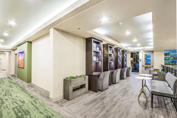 Clubhouse mezzanine with plush benches, round tables, and railings overlooking lounge.