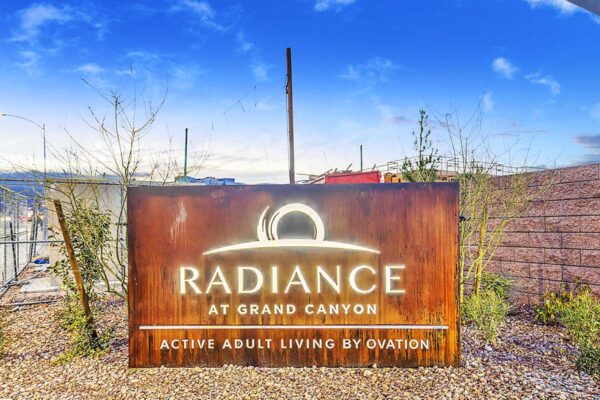 Radiance at Grand Canyon entrance with rustic monument sign.