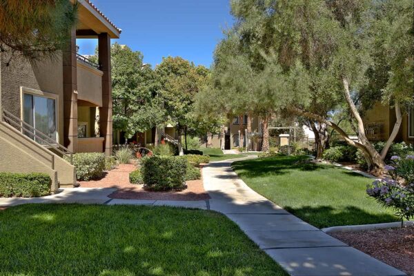San Croix apartments with lush landscaping, tall trees, paved walkways, and green lawns.